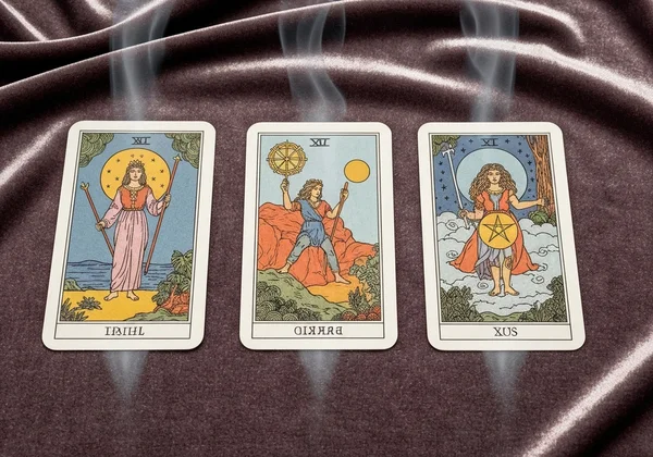 A three-card tarot spread with one card reversed